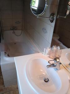 ein Badezimmer mit einem Waschbecken, einem Spiegel und einer Badewanne in der Unterkunft Chambres d'Hôtes Entre Deux Rives in Honfleur