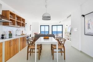 una cucina e una sala da pranzo con tavolo e sedie bianchi di Modern Design House with Roof Terrace a Poris de Abona