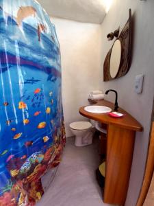 uma casa de banho com uma cortina de chuveiro temática de aquário ao lado de um WC em Pousada Chácara Lago Seco em Camocim