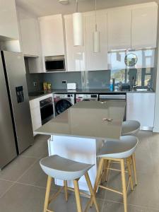 eine Küche mit einem Tisch und 4 Stühlen in der Unterkunft Flat 14 Block 6 Bellamare in Port Elizabeth