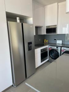 La cuisine est équipée d'un réfrigérateur en acier inoxydable et d'un lave-vaisselle. dans l'établissement Flat 14 Block 6 Bellamare, à Port Elizabeth