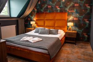 een slaapkamer met een bed met twee handdoeken erop bij Hotel Styl 70 in Pszczyna