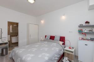 a white bedroom with a bed and a bathroom at Apartment & Rooms Primi with FREE PARKING in Dubrovnik