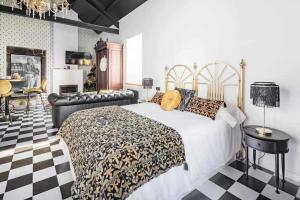 a bedroom with a bed and a checkered floor at La Suite Años 20. Bañera, chimenea y terraza. in Corcubión