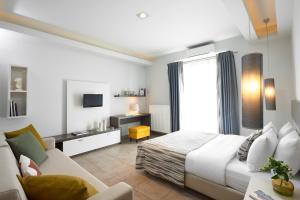 1 dormitorio con cama, sofá y TV en Maison Hotel, en Halkidona
