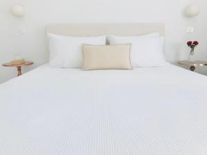 a white bed with a white comforter and pillows at Villa Fotini in Firostefani