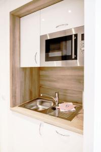 eine Küche mit Spüle und Mikrowelle in der Unterkunft Haus am See Luxury HS 949 B in Hahnenklee-Bockswiese