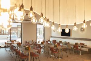 a dining room with tables and chairs and lights at the niu Star - Apartments in Sindelfingen
