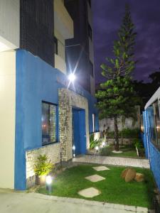 un edificio azul con una puerta azul por la noche en Flat confortável e bem localizado, en Natal