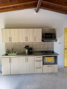 a kitchen with a stove and a sink and a microwave at Apartamento remodelado en el mejor lugar del centro de Medellín. Home Aris 402 in Medellín