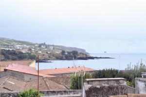 a view of a body of water with houses and a town at Sunrise House- 4 bedroom house with amazing sunrise over the sea 10 guests in Vila Franca do Campo