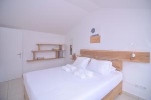 a bedroom with a white bed with towels on it at Sunrise House- 4 bedroom house with amazing sunrise over the sea 8 guests in Vila Franca do Campo