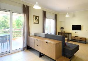 a living room with a couch and a tv at Botanica Villas & Apartments in Neos Marmaras