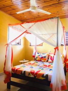 um quarto com uma cama de dossel em Villa CHRIS, Calme et Sérénité em Andilana