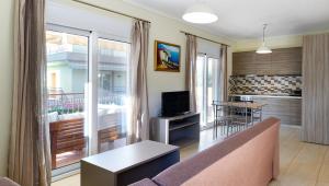a living room with a couch and a tv and a kitchen at Botanica Villas & Apartments in Neos Marmaras