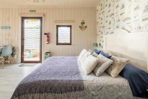 um quarto com uma cama grande com almofadas em Mar no Camiño Terraza bañera con vista al mar em Brens