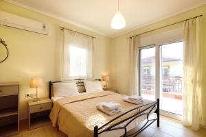 a bedroom with a bed and a large window at Botanica Villas & Apartments in Neos Marmaras