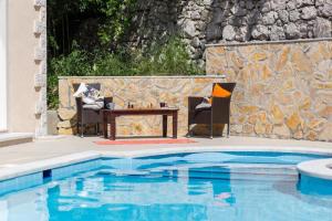 a table and chairs next to a swimming pool at Villa Avoca in Mlini