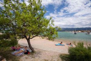 a group of people laying on the beach near the water at Apartment in Klimno/Insel Krk 12467 in Klimno