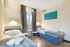 a hotel room with two beds and a window at Villa Artemys - Five Stars Holiday House in Saint-Jean-Cap-Ferrat