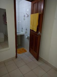 a bathroom with a shower and a door with a yellow towel at Yaya's House in Posorja