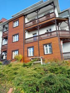 a large brick building with a balcony on it at Willa Halinówka in Krynica Zdrój