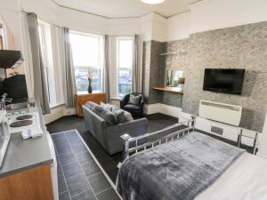 a bedroom with a bed and a couch and a tv at Mowbray 2 in Bridlington