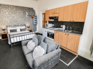 a living room with a couch and a kitchen at Mowbray 2 in Bridlington
