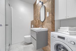 biała łazienka z pralką i umywalką w obiekcie Apartament 700 Apartamenty No. 1 Stare Miasto w Szczecinie