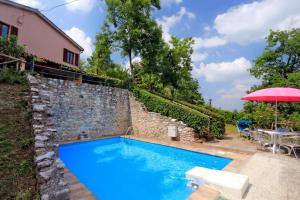 einen Pool mit einem Tisch und einem Sonnenschirm in der Unterkunft Villa Acacie in Sarnano