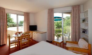 a bedroom with a bed and a room with a balcony at Les Hauts De Greoux in Gréoux-les-Bains