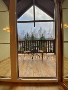 a view of a patio with a table and chairs through a window at Angelika 9D/3 Mountain Aparts in Świeradów-Zdrój