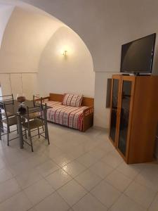 マルティナ・フランカにあるIl Nido Di Ederaのリビングルーム(ソファ、テーブル、椅子付)