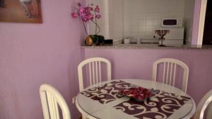 タリファにあるApartamento Tortuga Careyのピンクの壁のキッチン(テーブル、椅子付)