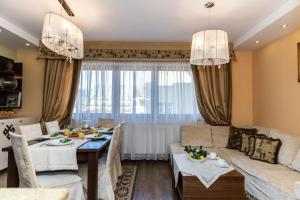 una sala de estar con una mesa y un sofá en Prestige II, en Zakopane