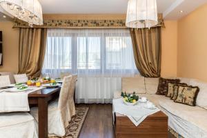 una sala de estar con una mesa y un sofá en Prestige II, en Zakopane