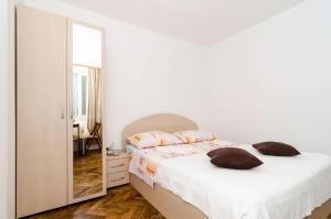 Habitación blanca con cama y espejo en Katarina Rooms, en Dubrovnik