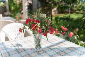 wazon czerwonych kwiatów na stole w obiekcie Katarina Rooms w Dubrowniku
