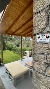 奧倫塞的住宿－Casa 2 Gallos，石墙上带长凳和标志的亭子