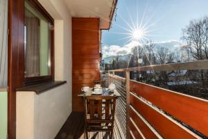 a balcony with a table and a view of the mountains at Prestige in Zakopane