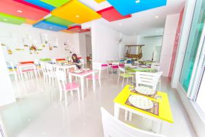 ein Zimmer mit Tischen und Stühlen und einer farbenfrohen Decke in der Unterkunft The Frutta Boutique in Patong Beach