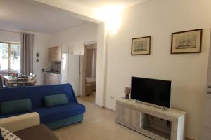 a living room with a blue couch and a tv at Casa vacanze Su Coru e Su Entu in Villamassargia