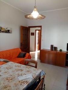 uma sala de estar com um sofá laranja e uma mesa em BRUNO TURIN APARTMENT Near the METRO em Collegno