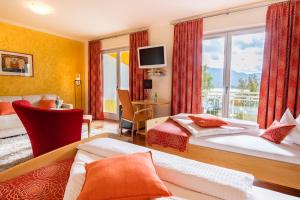 a hotel room with two beds and a window at Das Moser - Hotel Garni am See (Adults Only) in Egg am Faaker See
