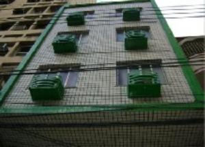 a building with green windows on the side of it at Hotel BELCENTRO in Belém