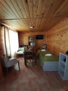 a bedroom with a green bed in a wooden room at Complejo "Nahuel Pan " in El Chalten