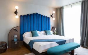 a bedroom with a large bed with a blue headboard at Hotel Barcelona Golf Resort 4 Sup in Martorell