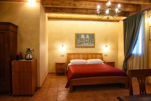 a bedroom with a bed with a red blanket at Agriturismo Corte Benetti in Rovigo