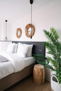 a bedroom with a bed with white sheets and a plant at Smartflats - Grand-Place I in Brussels