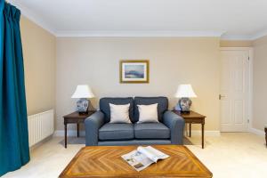 ein Wohnzimmer mit einem blauen Sofa und 2 Tischen in der Unterkunft Bright Tower Bridge Nest in London